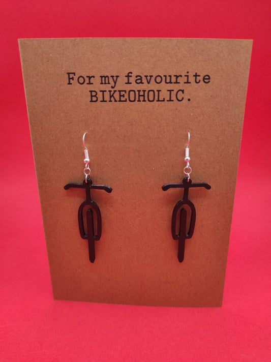 Wenskaart met oorbellen in de vorm van een fiets. Giftcard with earrings in the shape of a bike.
