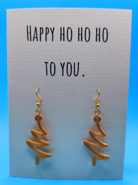 Wenskaart met oorbellen in de vorm van kerstboom. Giftcard with earrings in the shape of a christmas tree.
